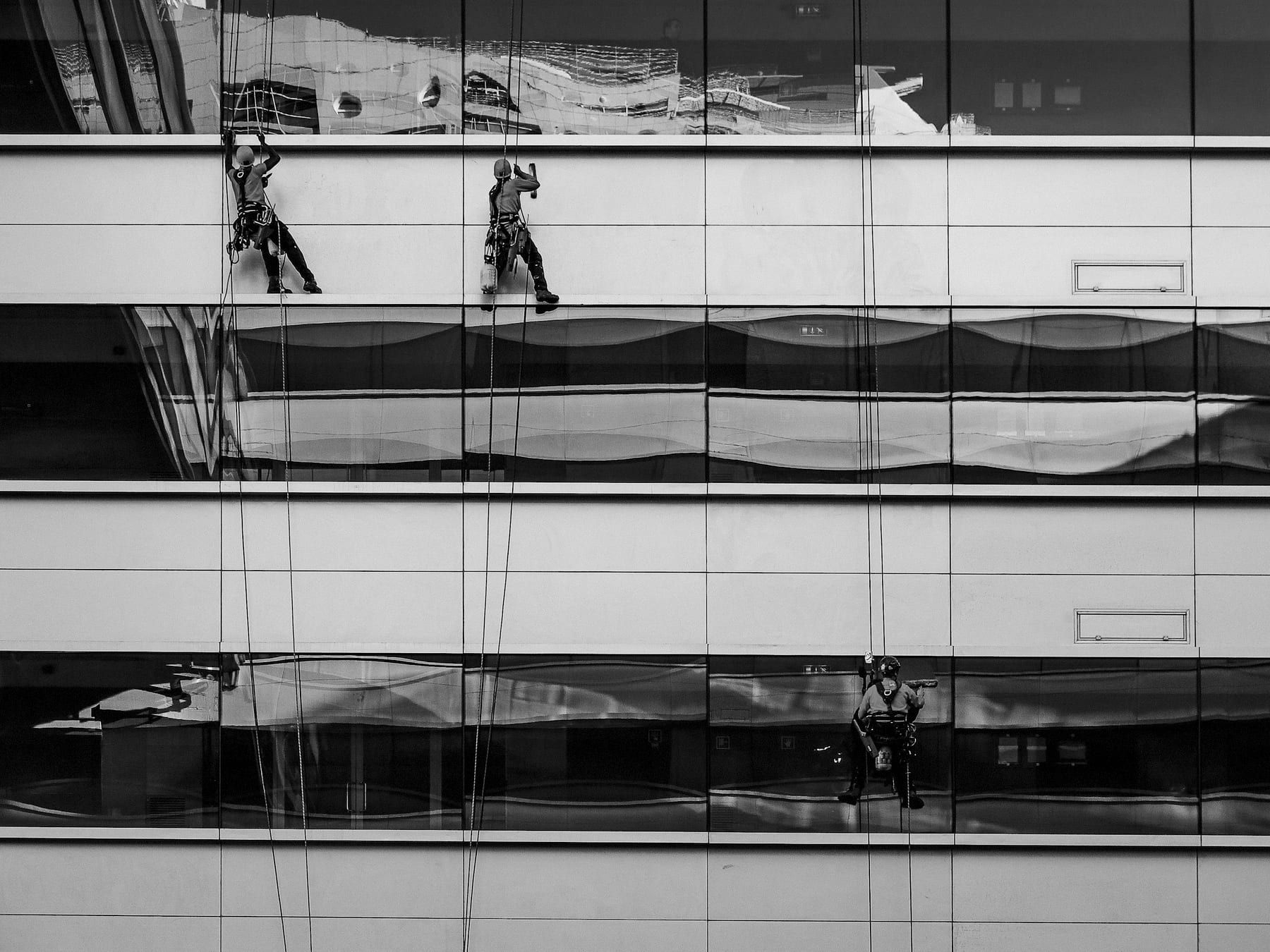 Rope access crew cleaning the glass facade of a commercial building